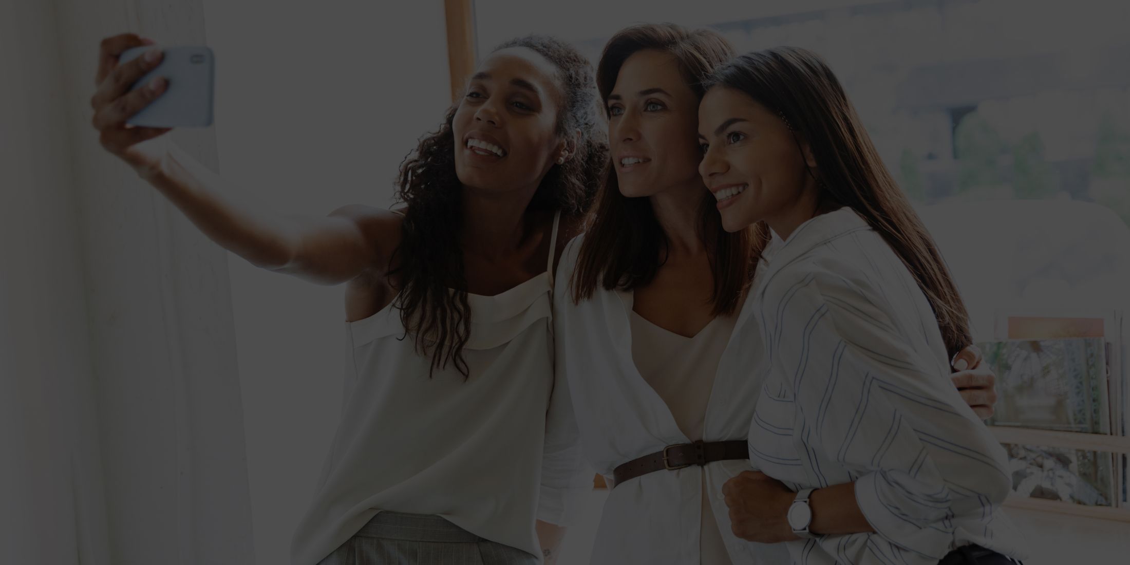 Friends taking a selfie together indoors.