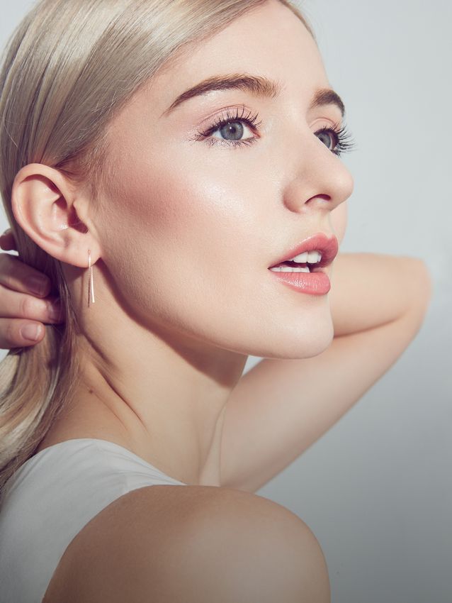 Close-up of woman with elegant makeup and earrings.